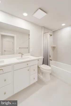 a bathroom with a double vanity sink toilet mirror and bathtub