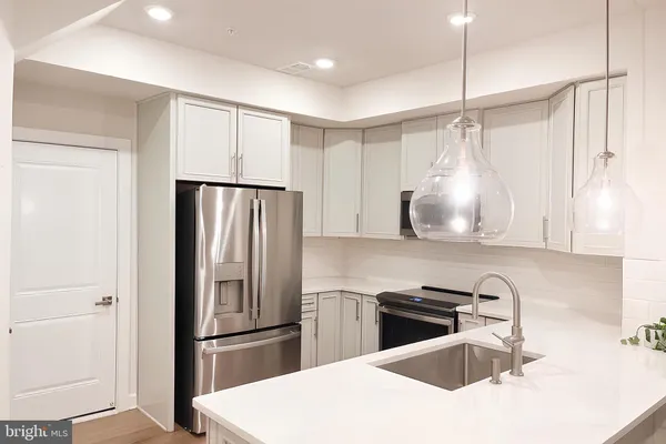 a kitchen with granite countertop a refrigerator and a sink