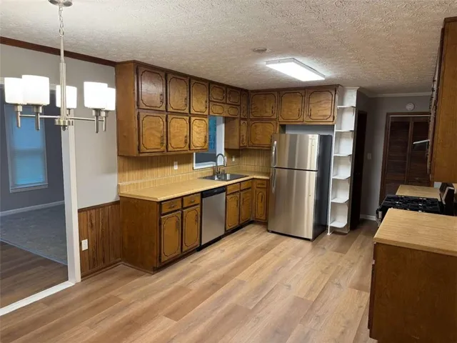 a kitchen with stainless steel appliances a refrigerator and wooden cabinets