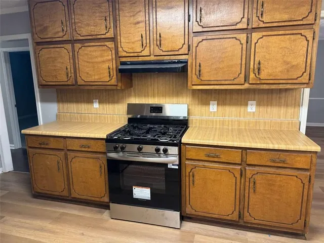 a kitchen with granite countertop cabinets stainless steel appliances and wooden floor