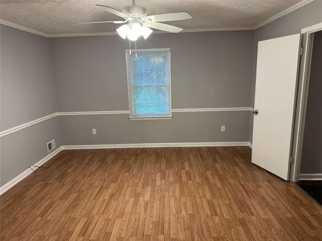 a view of a room with wooden floor and fan