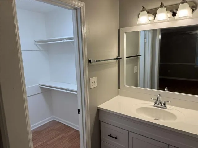 a en suite bathroom with a granite countertop sink and a mirror