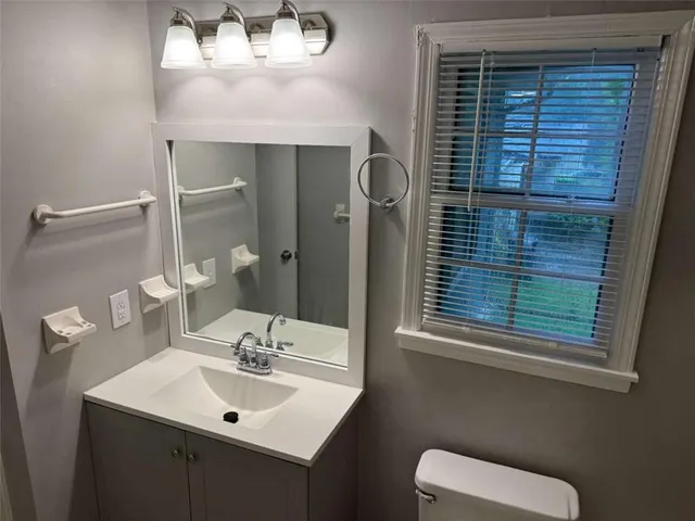 a bathroom with a toilet sink and mirror