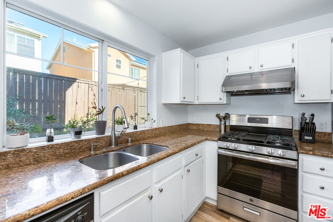 12248 Willowbend Lane Sylmar, CA 91342 - Photo 16 of 52 a kitchen with granite countertop a sink stainless steel appliances and cabinets