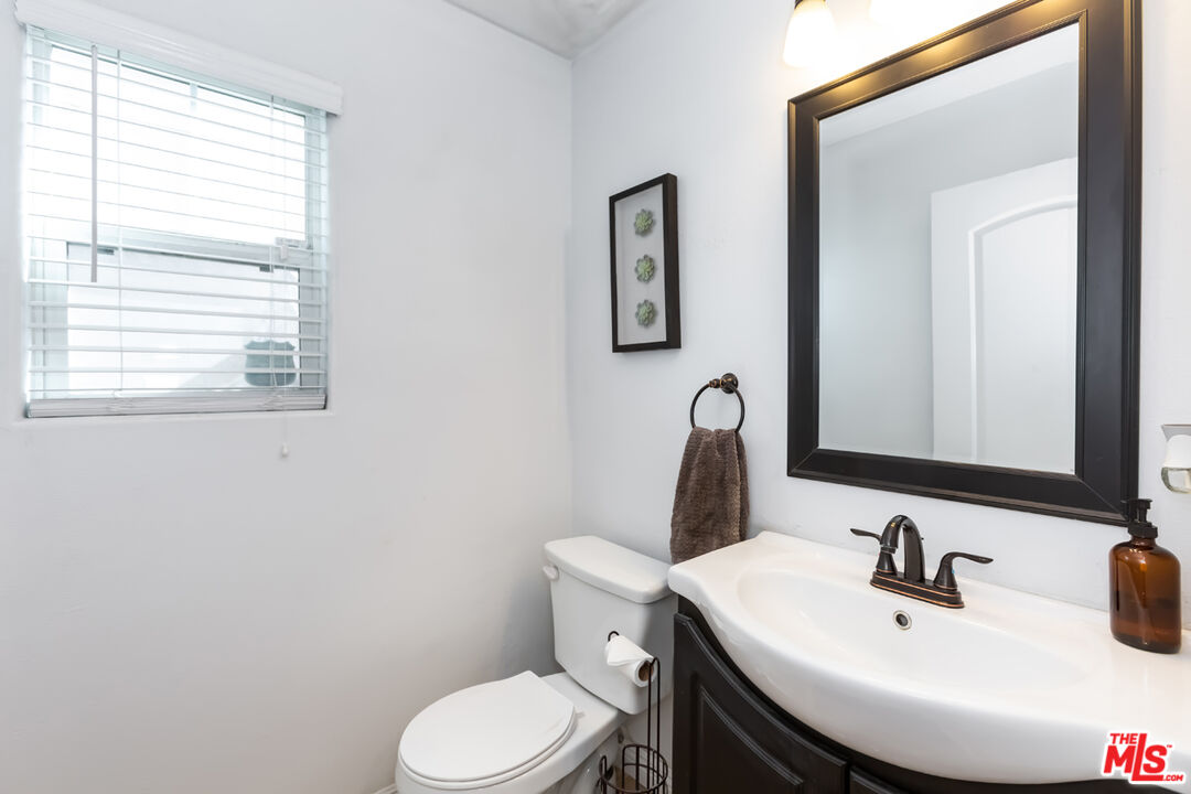 12248 Willowbend Lane Sylmar, CA 91342 - Photo 22 of 52 a bathroom with a toilet a sink and mirror