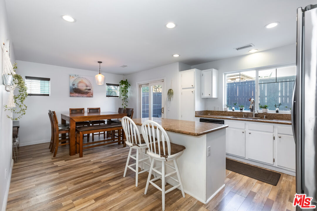 12248 Willowbend Lane Sylmar, CA 91342 - Photo 10 of 52 a kitchen with stainless steel appliances granite countertop wooden floor dining table and chairs