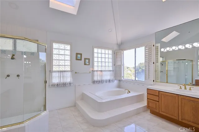 a spacious bathroom with a tub sink shower and mirror