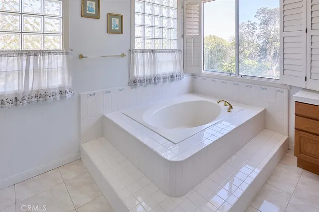 a white bath tub sitting in a bathroom next to a window