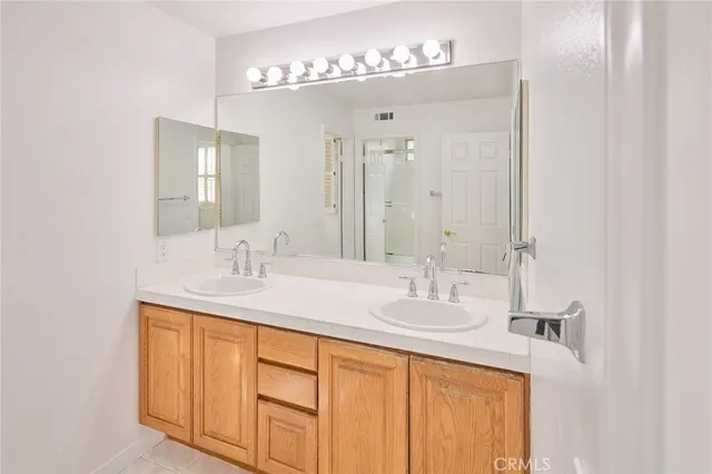 a bathroom with double sink and a mirror