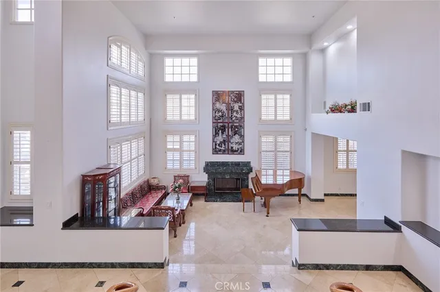 a living room with furniture large window and potted plants