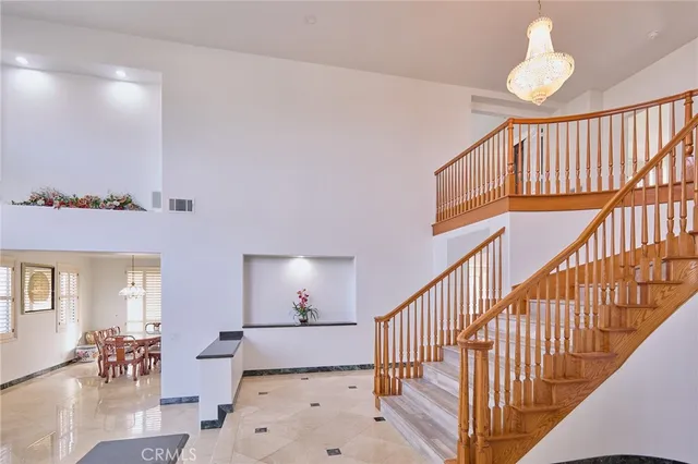 a view of a hallway with dining room and chandelier
