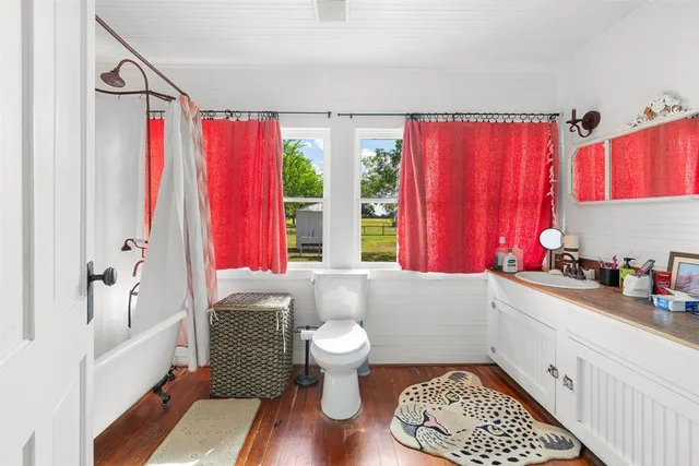 a bathroom with a sink toilet mirror and tub