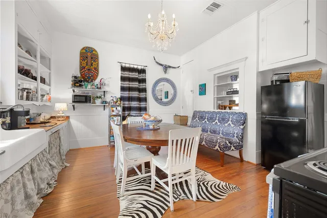 a view of a dining room with furniture a chandelier and wooden floor
