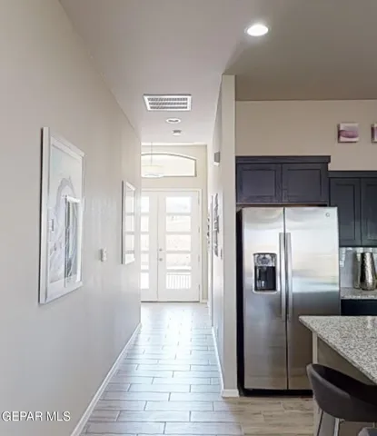 a kitchen with granite countertop a refrigerator and a sink