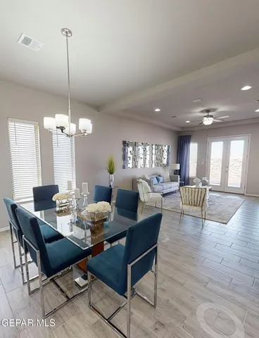 a dining room with furniture a chandelier and wooden floor