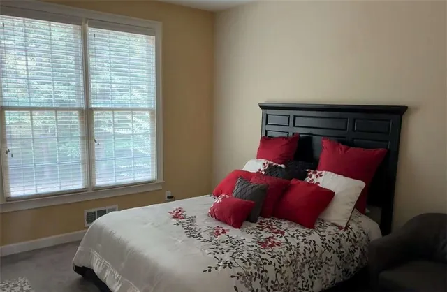 a bed sitting in a bedroom next to a window