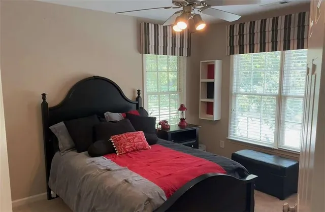a bedroom with a bed window and table