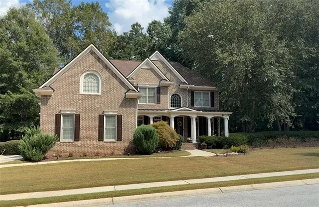 a front view of a house with a garden