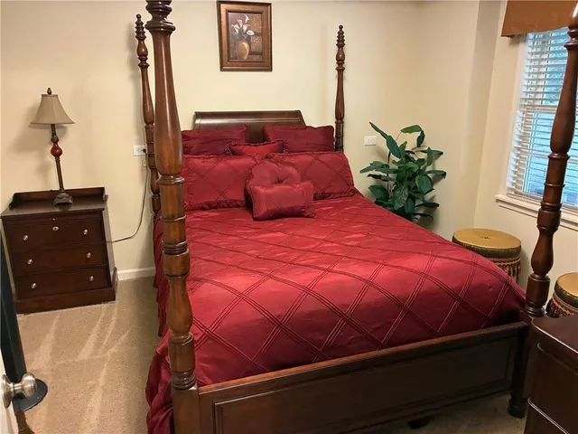 a large bed sitting in a bedroom next to a window