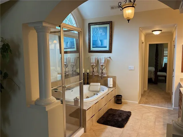 a bathroom with a tub a mirror and a sink