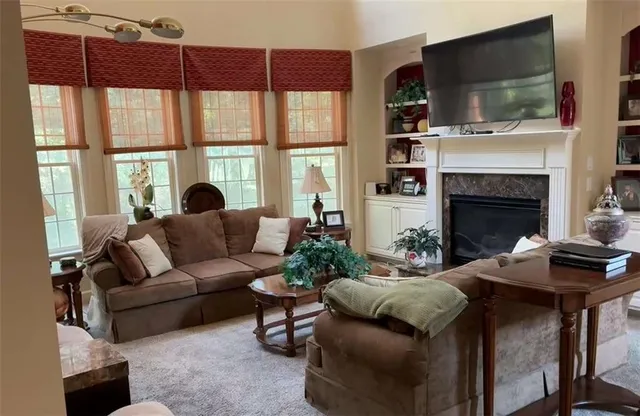a living room with furniture a flat screen tv and a fireplace