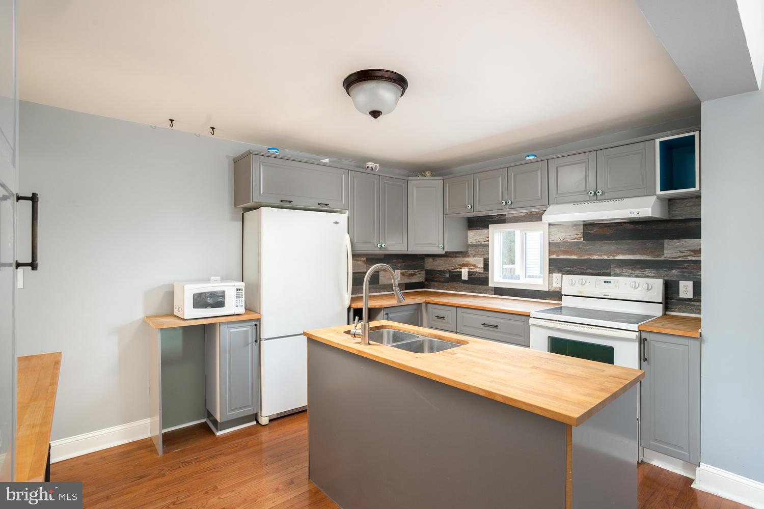 907 Bordentown Road Columbus, NJ 08022 - Photo 13 of 25 a kitchen with stainless steel appliances granite countertop a refrigerator a sink dishwasher a stove and white countertops with wooden floor
