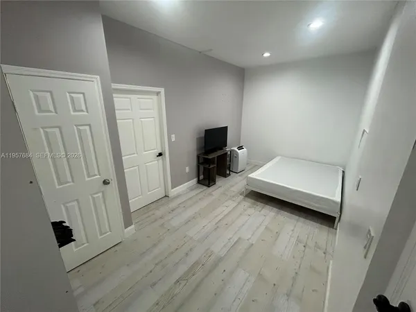 wooden floor in white room with stairs