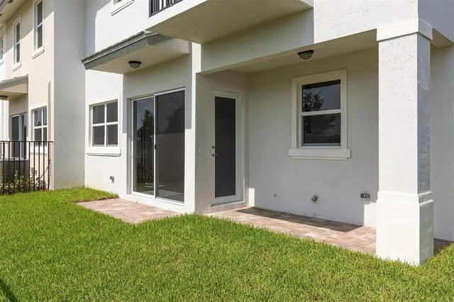 a view of a white house with a big yard and large tree