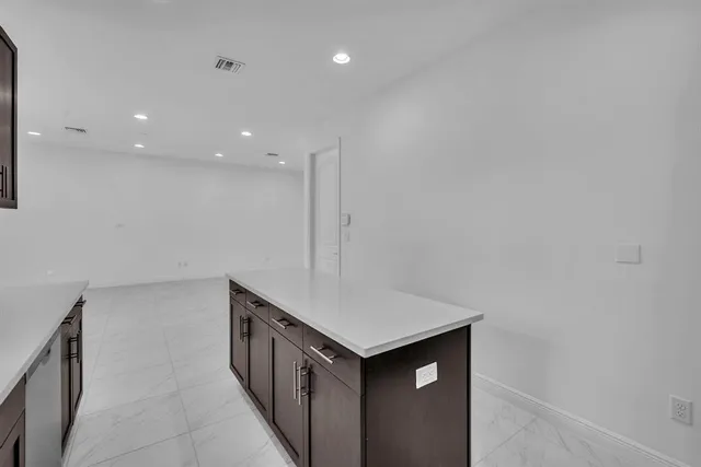 a kitchen with stainless steel appliances cabinets and wooden floor