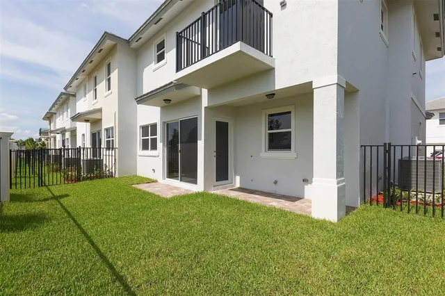 a view of a house with brick walls and a yard with plants