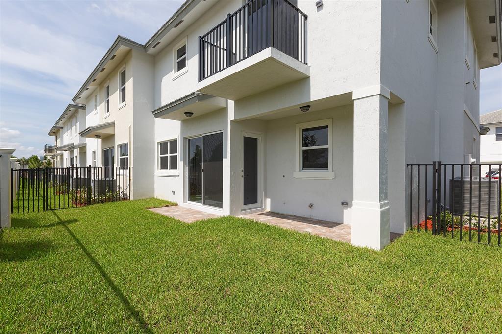 6947 Pines Circle, Unit 21 Pompano Beach, FL 33073 - Photo 3 of 31 a view of a house with brick walls and a yard with plants
