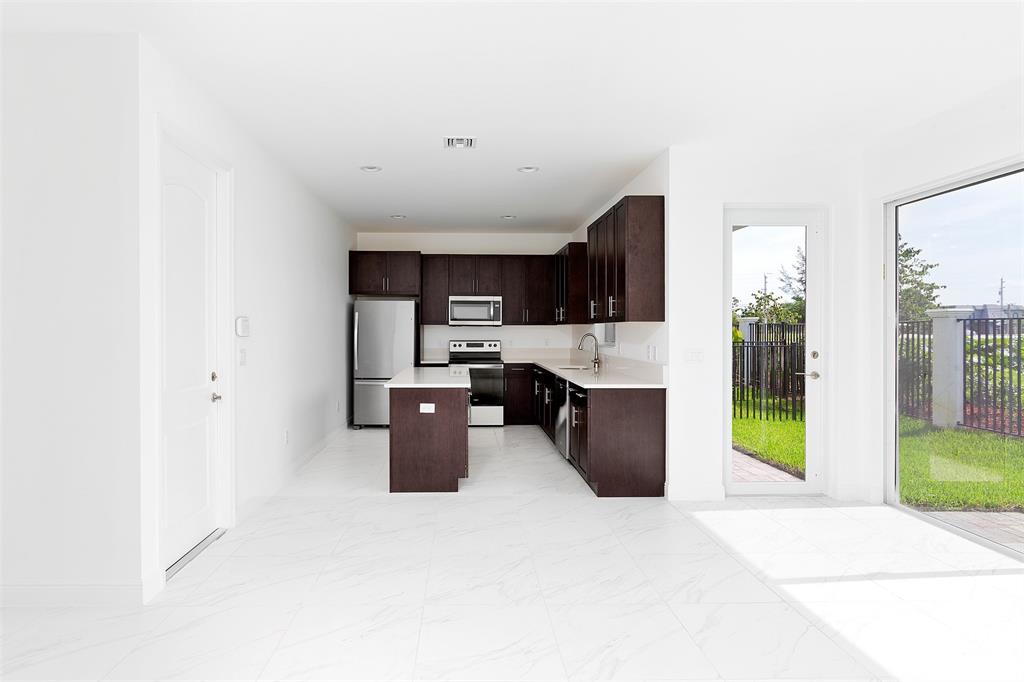 6947 Pines Circle, Unit 21 Pompano Beach, FL 33073 - Photo 6 of 31 a kitchen with stainless steel appliances a refrigerator and a sink