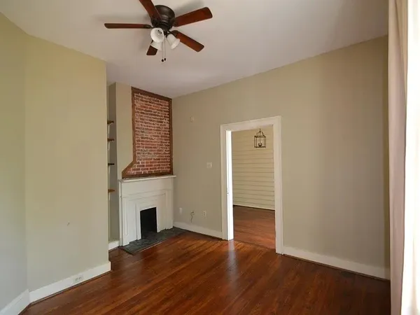 a view of empty room with wooden floor and fireplace