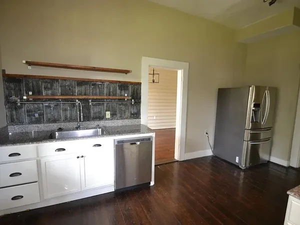 a kitchen with granite countertop a stove and a refrigerator