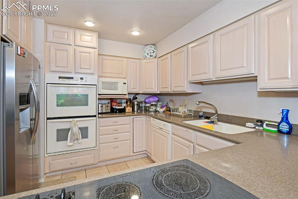 3670 Camels Ridge Lane Colorado Springs, CO 80904 - Photo 9 of 22 a kitchen with stainless steel appliances granite countertop a refrigerator sink and cabinets