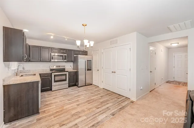 a large kitchen with kitchen island a sink stainless steel appliances and cabinets