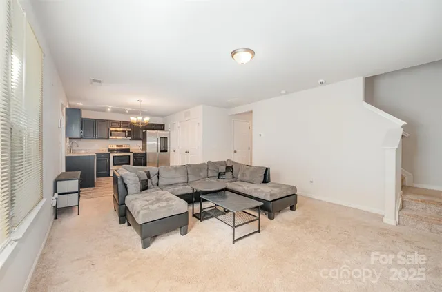 a living room with furniture and kitchen view