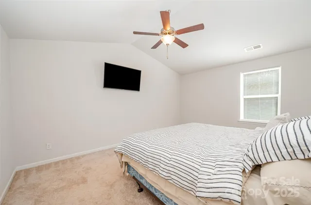a bedroom with a large bed and a flat screen tv