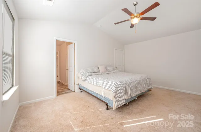 a bedroom with a bed and a ceiling fan