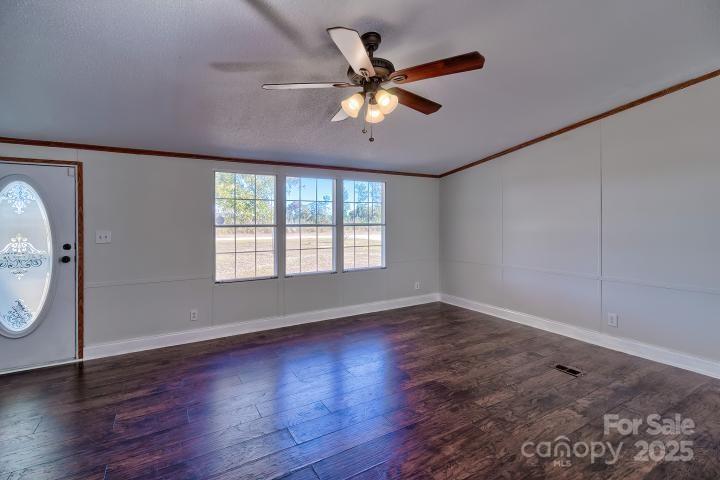 9552 Flat Creek Road Kershaw, SC 29067 - Photo 14 of 47 an empty room with wooden floor fan and windows