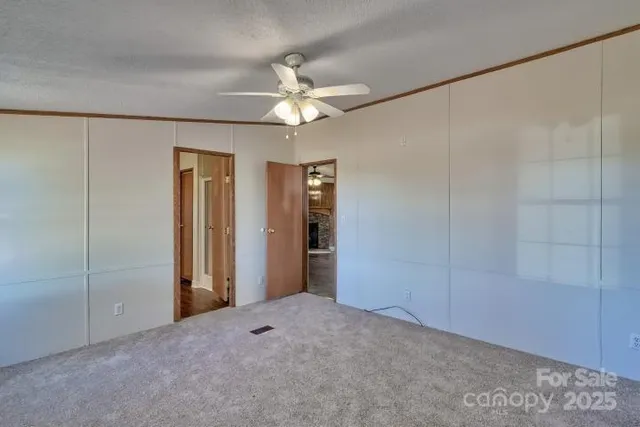 a view of an empty room with a ceiling fan