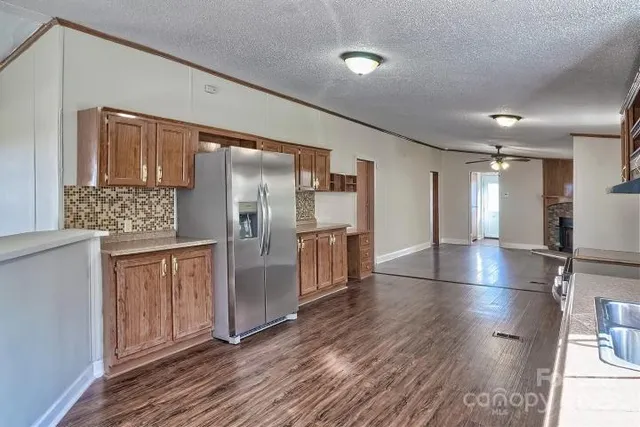a kitchen with stainless steel appliances a refrigerator and wooden floor