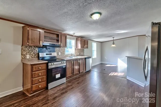 a kitchen with stainless steel appliances a refrigerator and a stove top oven