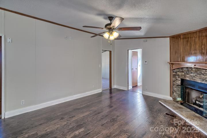 9552 Flat Creek Road Kershaw, SC 29067 - Photo 29 of 47 a view of an empty room with wooden floor a fireplace and a window