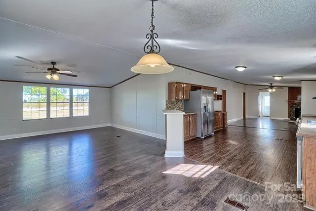 a view of a room with wooden floor chandelier and windows