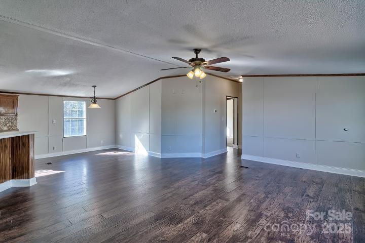 9552 Flat Creek Road Kershaw, SC 29067 - Photo 36 of 47 an empty room with wooden floor chandelier fan and windows