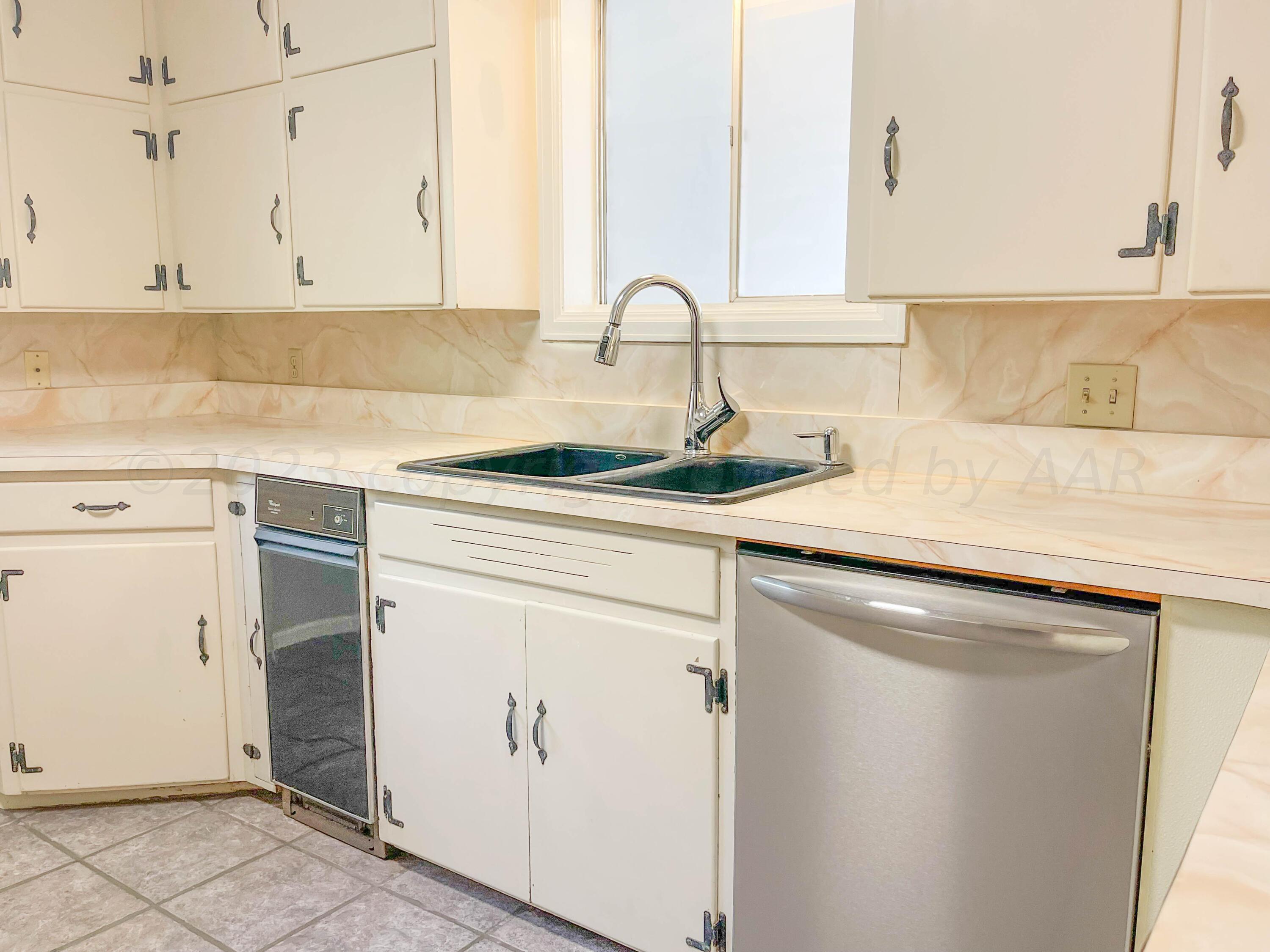 3707 Lynette Drive Amarillo, TX 79109 - Photo 12 of 45 a kitchen with stainless steel appliances granite countertop a sink and a white cabinets
