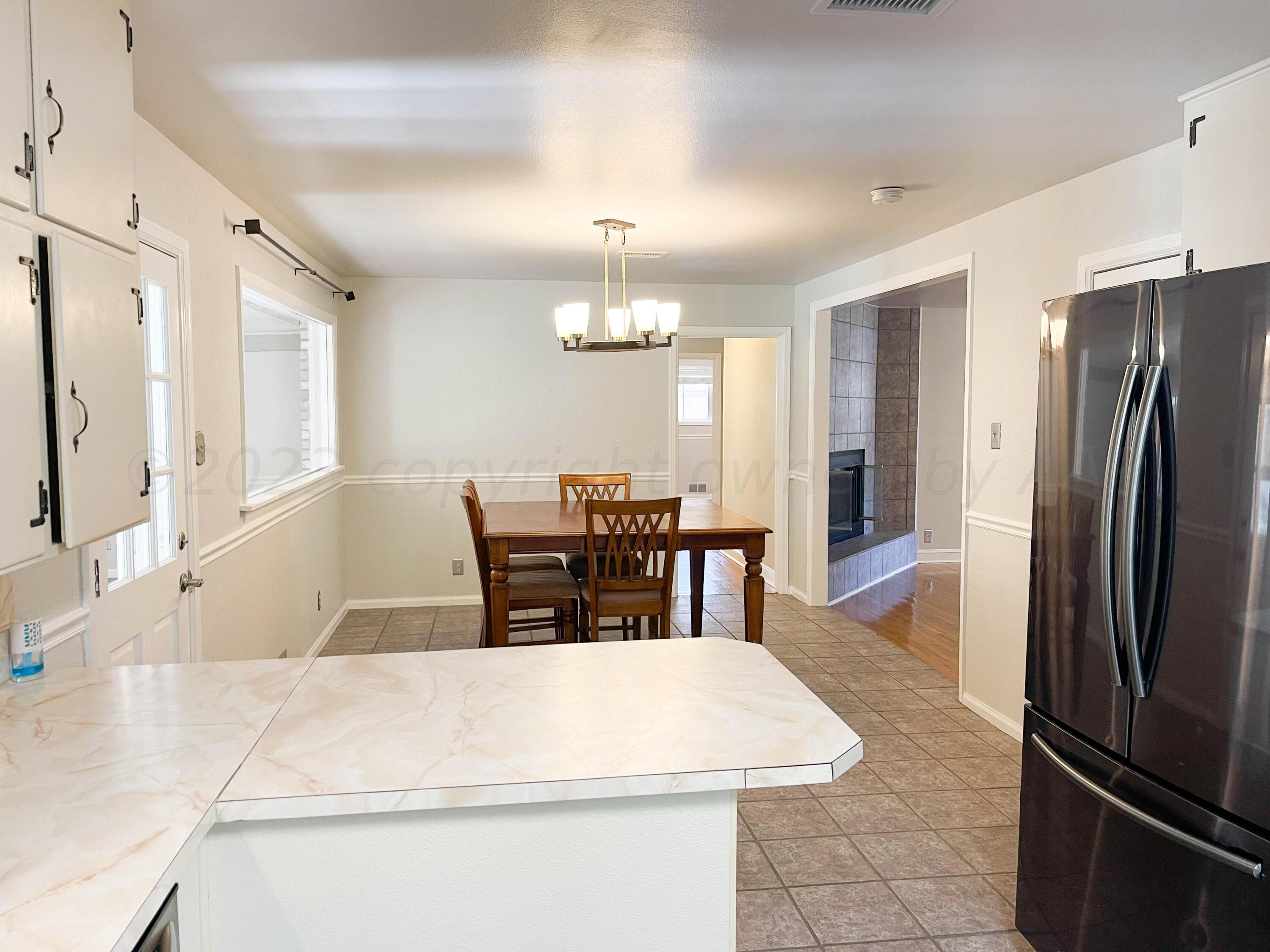 3707 Lynette Drive Amarillo, TX 79109 - Photo 13 of 45 a dining hall with stainless steel appliances granite countertop a dining table chairs and a refrigerator
