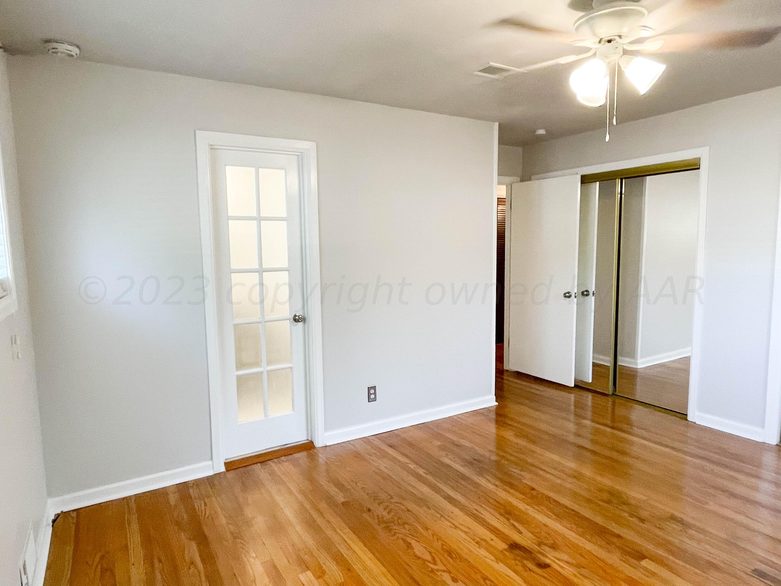 3707 Lynette Drive Amarillo, TX 79109 - Photo 23 of 45 an empty room with wooden floor and windows