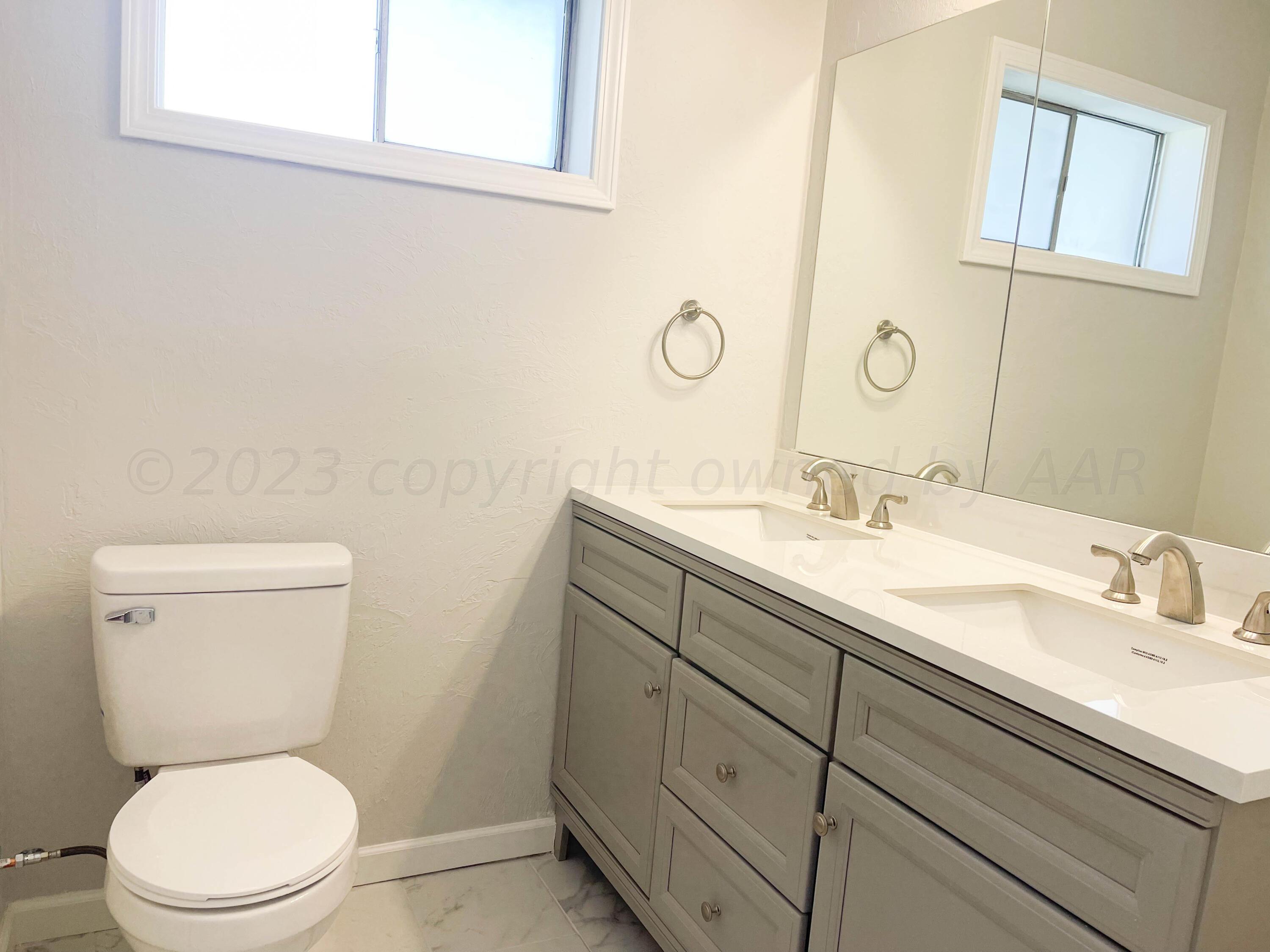 3707 Lynette Drive Amarillo, TX 79109 - Photo 25 of 45 a bathroom with a toilet sink and mirror